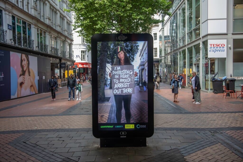 Billboards in the Loop, New Street, Birmingham. Leading environmental and human rights groups - Amnesty International UK, Friends of the Earth, Greenpeace and Liberty - launch a nationwide advertising campaign to stand up for the right to protest. The campaign features videos of real protesters on a range of issues holding placards that say ‘I’m protesting in here to avoid arrest out there’.The protesters appear on digital billboards clustered in popular shopping areas in London, Birmingham and Manchester, given free to the campaign as the prize in Ocean Outdoor’s annual Digital Creative Competition.